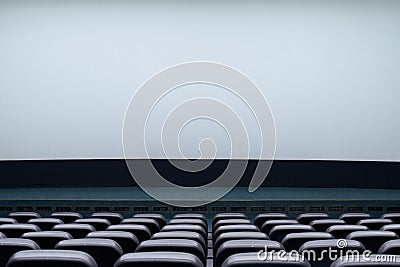 Large blank screen and rows black seats in cinema hall. Stock Photo