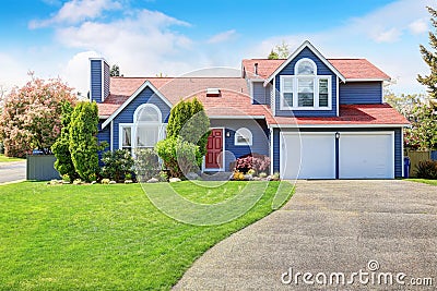 Large blue house with white trim and a nice lawn. Stock Photo