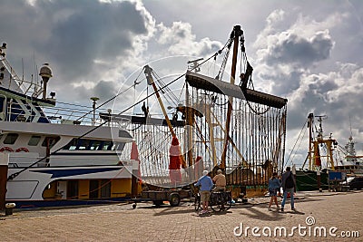 Large bottom trawling fishing nets ot Dutch cutter boat anchored in Oudenshild garbor on island Texel Editorial Stock Photo