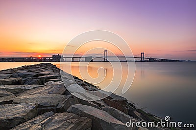 Large bridge crossing still body of water, reflections in the water. Throggs Neck Bridge, Queens New York Stock Photo