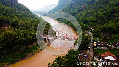 A large bridge divides the dark brown river Stock Photo