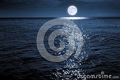 Large Bright FUll Moon Rises Over A Calm Ocean Scene Stock Photo