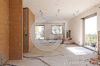 Large bright room with windows of an ancient villa undergoing renovation. The old walls have been torn down and new ones have been Stock Photo