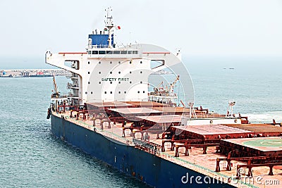 A large bulk carriers, tugboats at the port under cargo operations and underway. Close-up view of ships constructions and equipmen Stock Photo