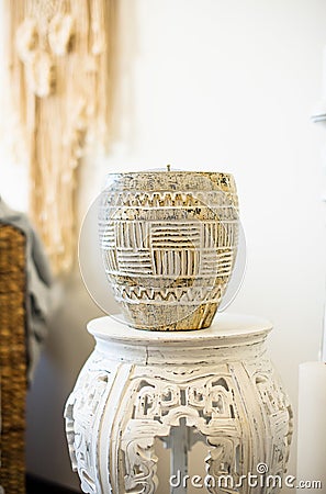 A large candle in a vase on a white table in boho style Stock Photo