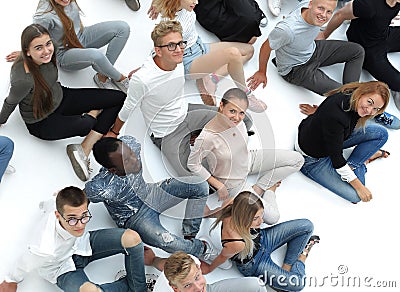 Large casual group of young people sitting on the floor. Stock Photo