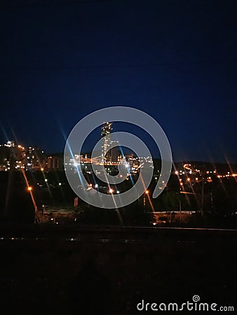 large cement factory, kind of at night, lamps are lit Stock Photo