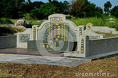 Large Chinese grave and tombstone with golden Mandarin writing at cemetery Ipoh Malaysia Editorial Stock Photo