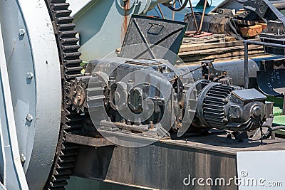 Large cogwheel. Metal Gear. The mechanism of the port crane. Old paint. Stock Photo