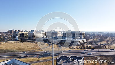 Large college campus near I-235 Highway loop with office buildings and rooftop parking garage, busy downtown Centennial Expressway Stock Photo