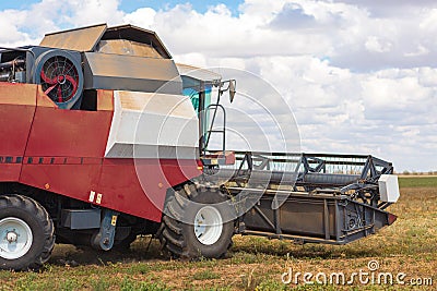 A large combine works in a wheat field Stock Photo