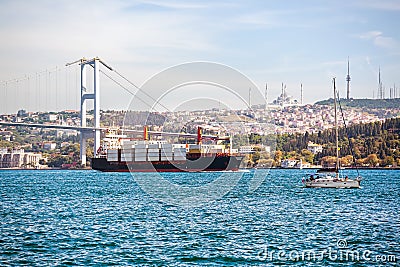 Large container ship and yacht in the Bosphorus Strait Stock Photo