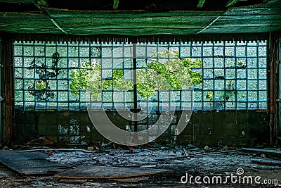 Large corrugated, broken window with a pattern in the corridor of an abandoned building Stock Photo