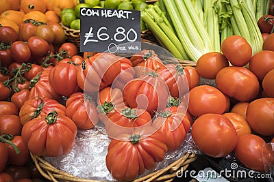 Large cow heart tomatoes for sale on farmers market stall Editorial Stock Photo