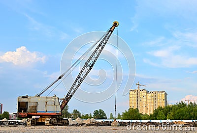 Large crawler crane or dragline excavator with a heavy metal wrecking ball on a steel cable. Stock Photo