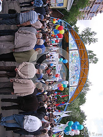 A large crowd of people gathered near the stage in the Park watching the performance of artists Editorial Stock Photo