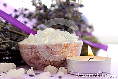 Large crystals of sea salt and lavender flowers, lit candle. Stock Photo