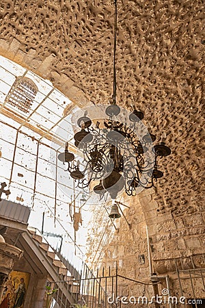 A large decorative lamp hangs from a ceiling in the interior of the St. Jacobs orthodox cathedral Jerusalem in Christian Editorial Stock Photo