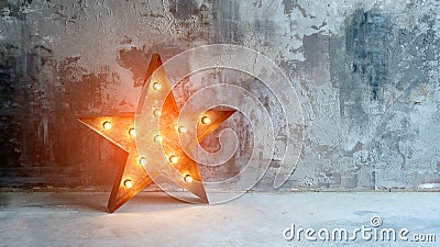 Large decorative retro star with lots of burning lights on grunge concrete background. Beautiful decor, modern design Stock Photo