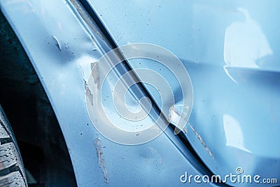 A large dent and cracked on the side wing of a blue car after an accident. Accident, car repair, insurance Stock Photo