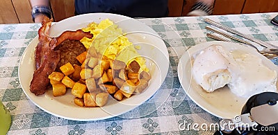 The large diner breakfast of scrambled eggs, bacon, sausage, Hashbrowns, and biscuits and gravy Stock Photo