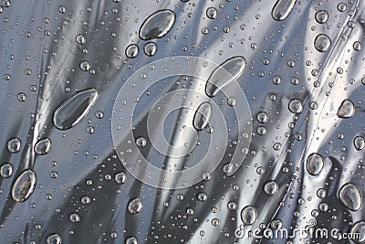 Large drops of water on a background of black polyethylene. Background image. Stock Photo