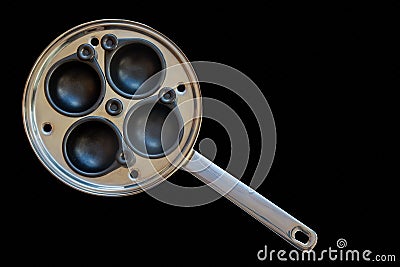 A large egg poacher isolated on a black background Stock Photo