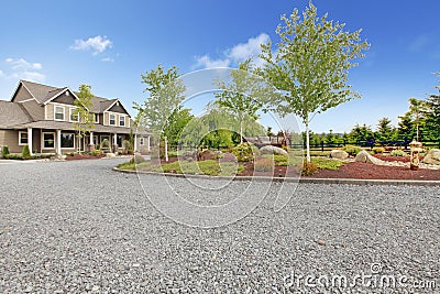 Large farm country house with gravel driveway and green landscape. Stock Photo