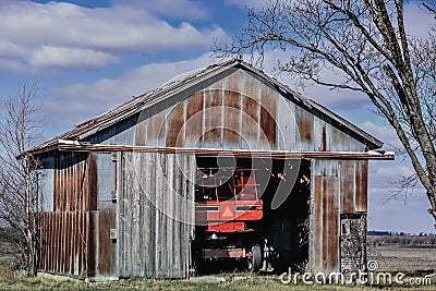 Large Farm Tractor Inside Rustic Shed Stock Photo