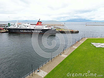Large ferry boat traversing a harbor on a cloudy day in Ardrossan Marina, Scotland Editorial Stock Photo