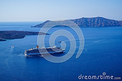 Large ferry ship and speed boats sailing on vast blue mediterranean sea with caldera mountain and sky background Stock Photo
