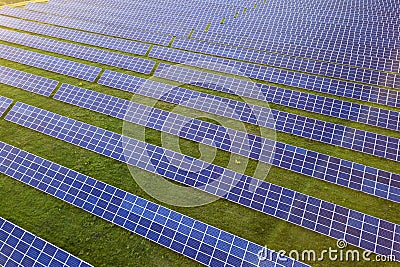Large field of solar photo voltaic panels system producing renewable clean energy on green grass background Stock Photo