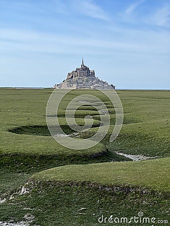 A large french monument Mont Saint Michel behind a huge meadow Stock Photo