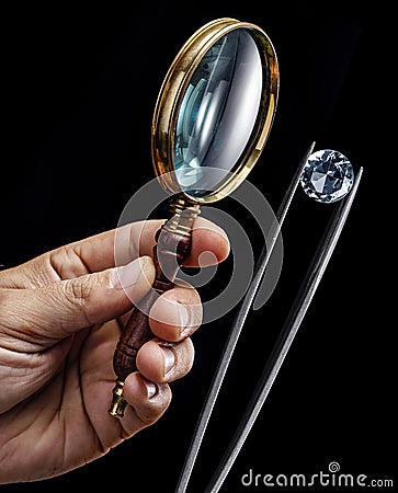 Large gemstone and loupe in jeweler's hands close up. Gem identifying and evaluating process Stock Photo