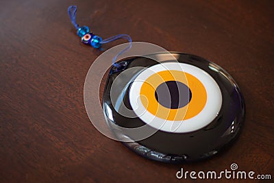 Large glass Turkish evil eye on wooden table Stock Photo