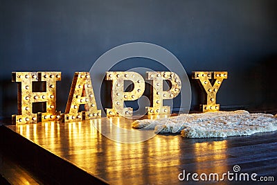 Large glowing letters happy in the interior Stock Photo