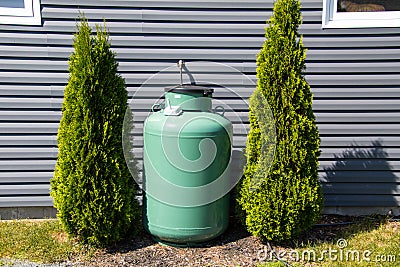 A large green propane tank on the side of a house Stock Photo