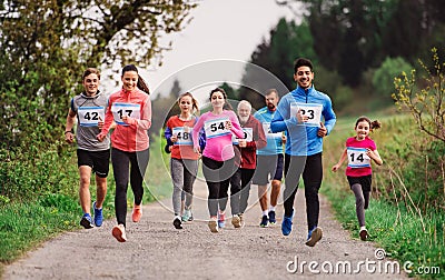 Large group of multi generation people running a race competition in nature. Stock Photo