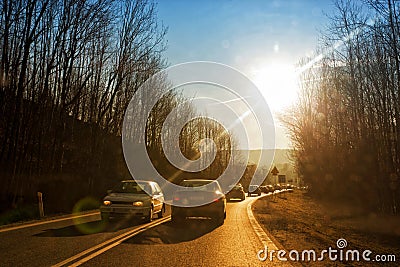 Cars driving down country road Stock Photo