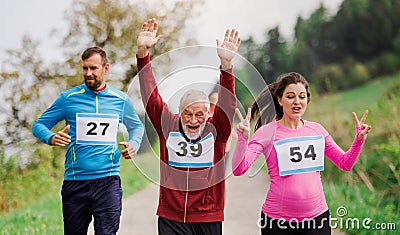 Large group of multi generation people running a race competition in nature. Stock Photo