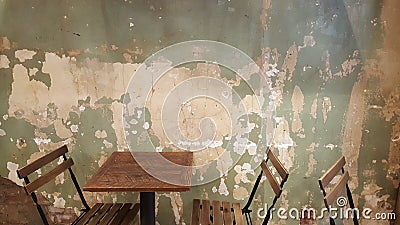 restaurant folding chairs and tables with distressed and chipping white green wall Stock Photo