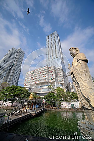Large Guanyin statue, Seema Malakaya temple over Beira Lake, in juxtaposition with skyscrapers of Colombo City Mall & Altair Condo Editorial Stock Photo
