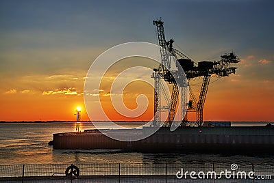 Large harbor crane in front of colorful sunset Stock Photo