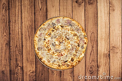 A large Italian family style carbonara pizza viewed from above on a warped wooden table Stock Photo