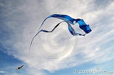 A large kite of blue color, made of silk, and a little multicolored Stock Photo