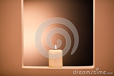 Large lighted candle on a shade background Stock Photo