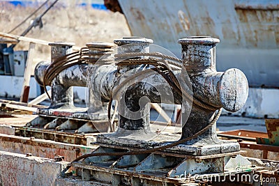 Large metal bollards with spooled steel ropes for mooring ships Stock Photo