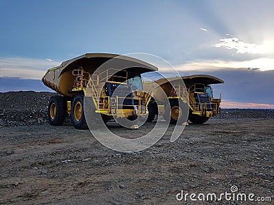 Large mine mining earth moving trucks construction twilight Stock Photo