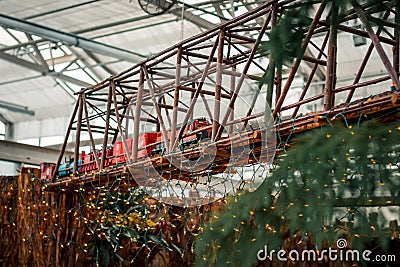 Large model locomotive going over a bridge in a holiday display Editorial Stock Photo