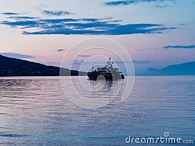 Modern Luxury Motor Cruiser Boat Anchored in Bay at Dawn, Greece Stock Photo